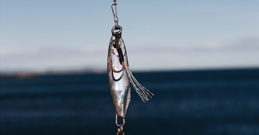 Close-up of a fishing lure hanging against a clear blue sea backdrop, ideal for outdoor and fishing themes.